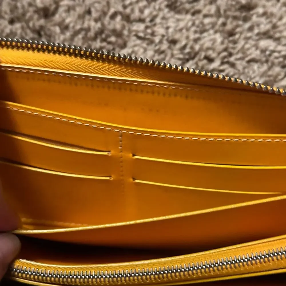 Goyard Matignon zip-around wallet in yellow orange Goyardine canvas.
